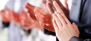 Photo of business partners hands applauding at meeting.